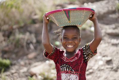 Girl carrying a basket and smiling 