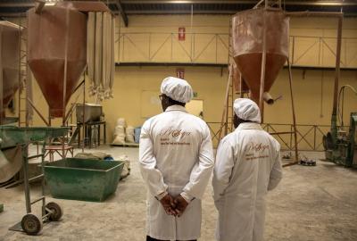 Prosoya CEO and TechnoServe staff standing inside processing facility 