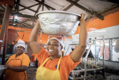 Women holding silver bucket above head