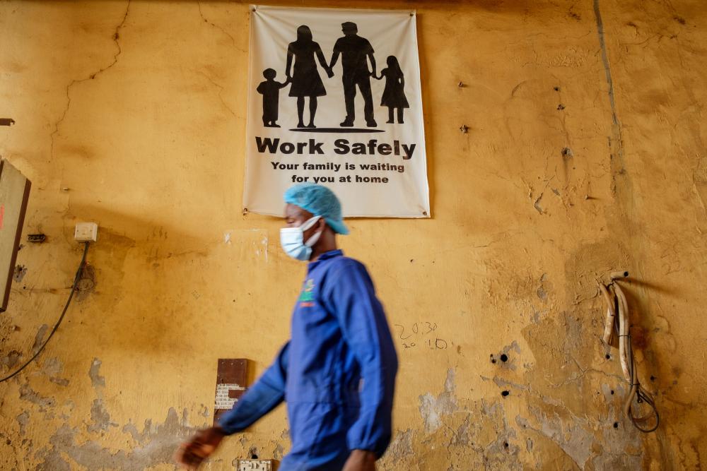 Employee in front of safety banner