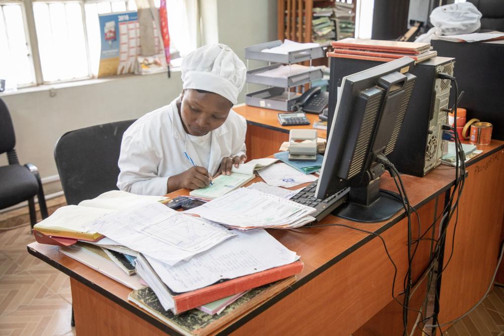 Women writing on papers in office